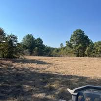 A atv is parked in a field with trees in the background.