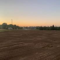 A large dirt field with a sunset in the background.