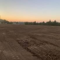 A large dirt field with a sunset in the background.
