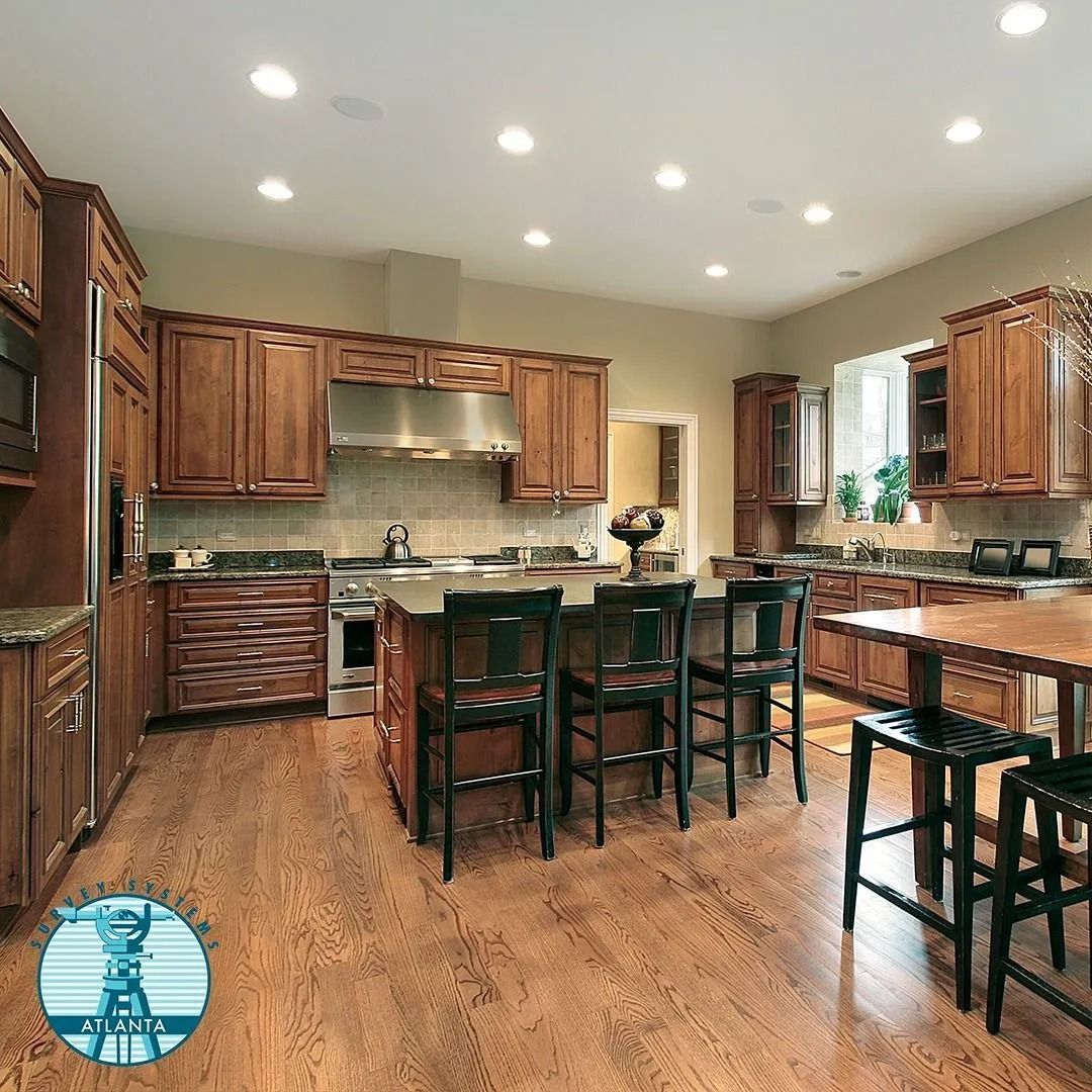 Spacious kitchen with wood cabinets, island with seating, and stainless steel appliances.