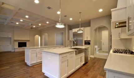 A kitchen with white cabinets , stainless steel appliances , and hardwood floors.