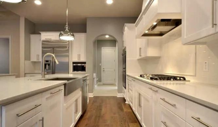 A kitchen with white cabinets and stainless steel appliances.