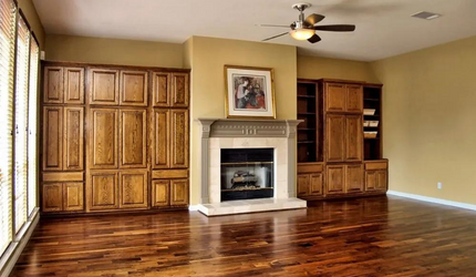 An empty living room with hardwood floors and a fireplace