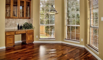 An empty room with hardwood floors and a desk.