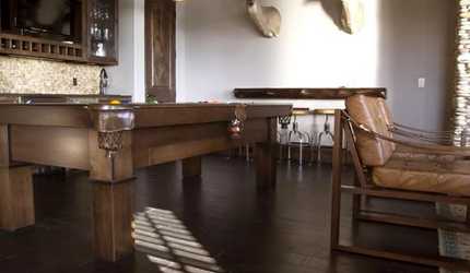 A room with a pool table and chairs in it