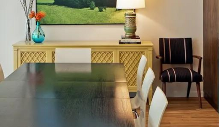 A dining room with a table and chairs and a lamp