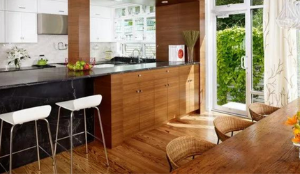 A kitchen with a table and stools and a sliding glass door