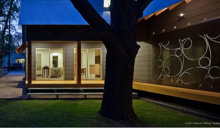 A house with a blue roof and a tree in front of it