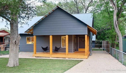 A small house with a porch and chairs on it