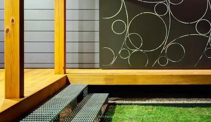 A staircase leading up to a porch with a painting on the wall.