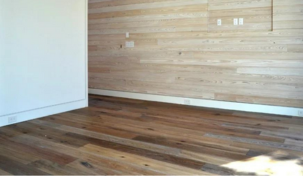 A room with a wooden floor and a wooden wall.