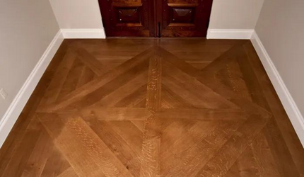 A wooden floor with a geometric pattern in a room.