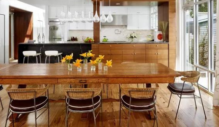 A dining room with a large wooden table and chairs