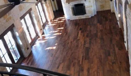 An aerial view of a living room with hardwood floors and a fireplace.