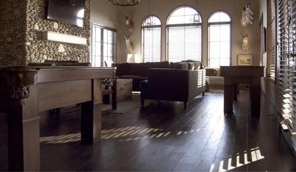 A living room with a pool table and a couch.