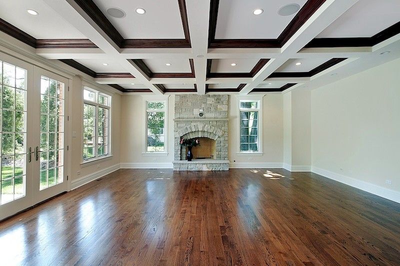 An empty living room with hardwood floors and a fireplace