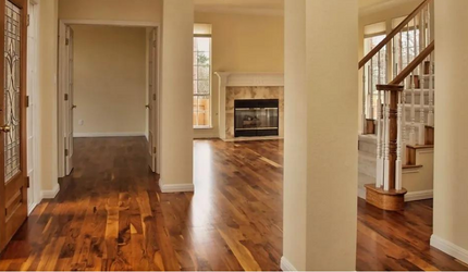 A hallway in a house with hardwood floors and a fireplace.