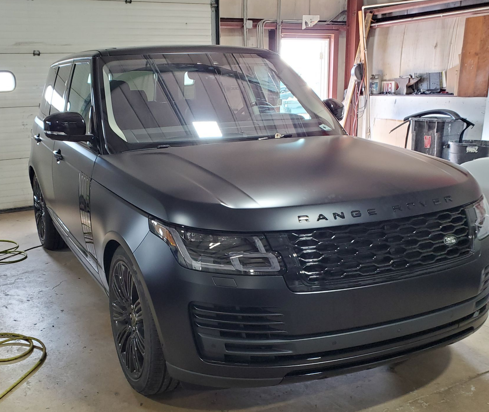 Black matte Range Rover parked inside a garage.