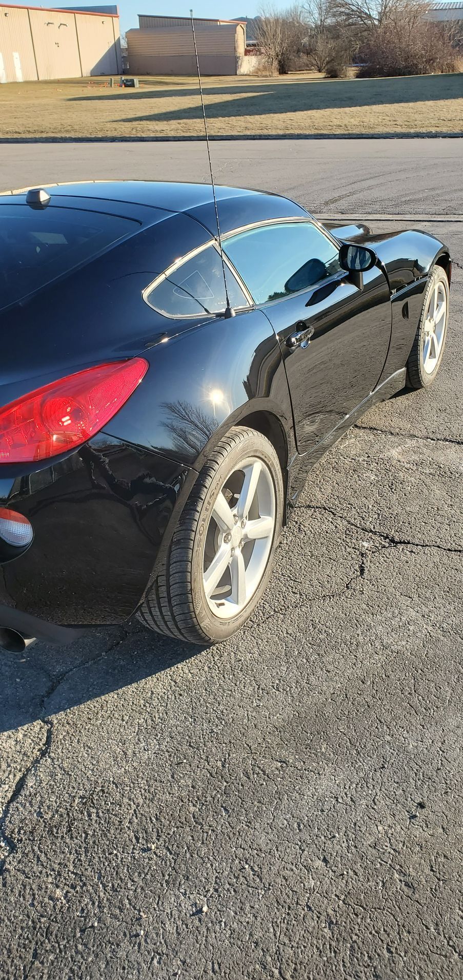 Black sports car parked on asphalt.