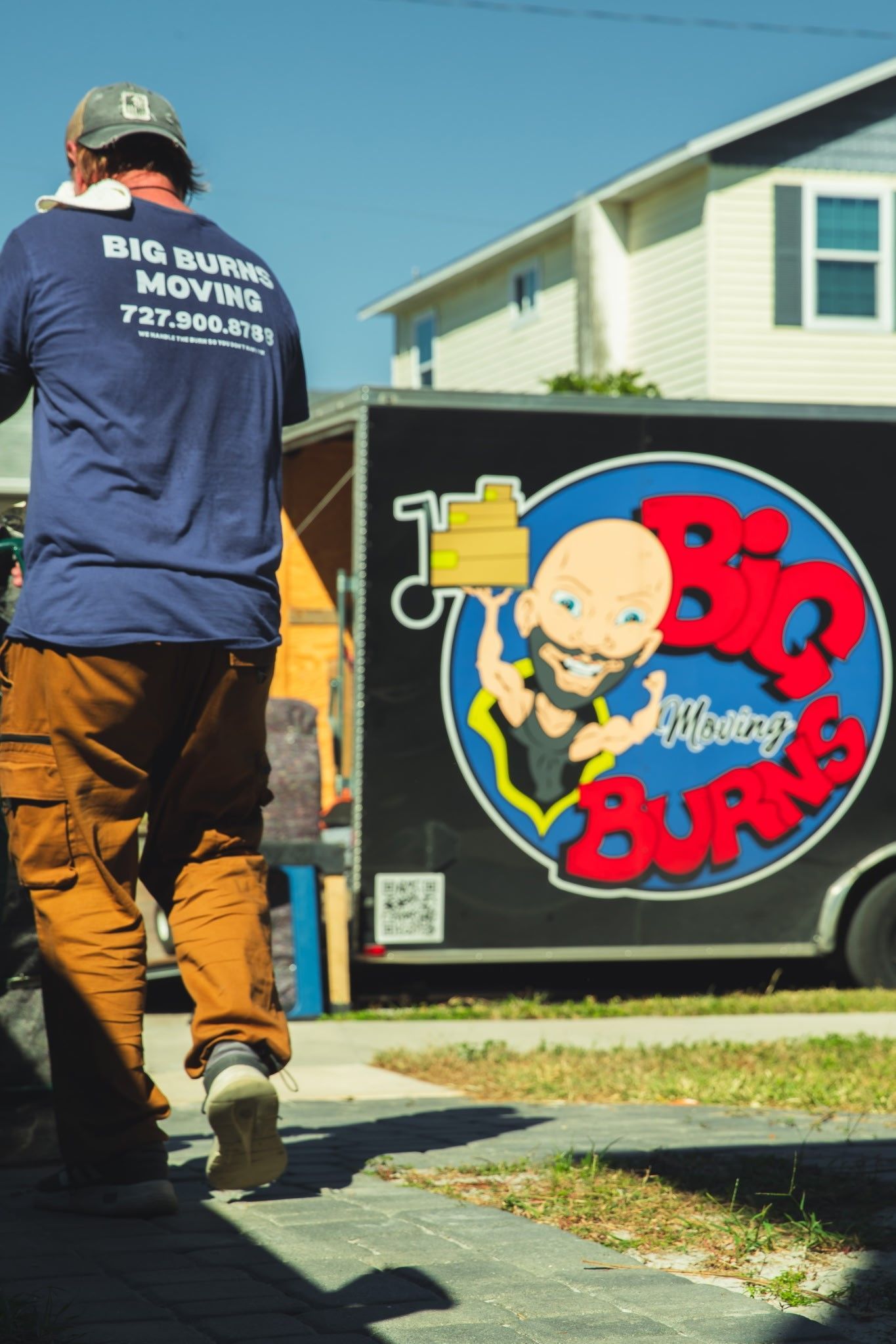 Person walking beside a truck with a colorful Big Buns logo mural.