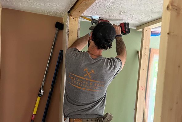 A man is working on a ceiling with a drill.