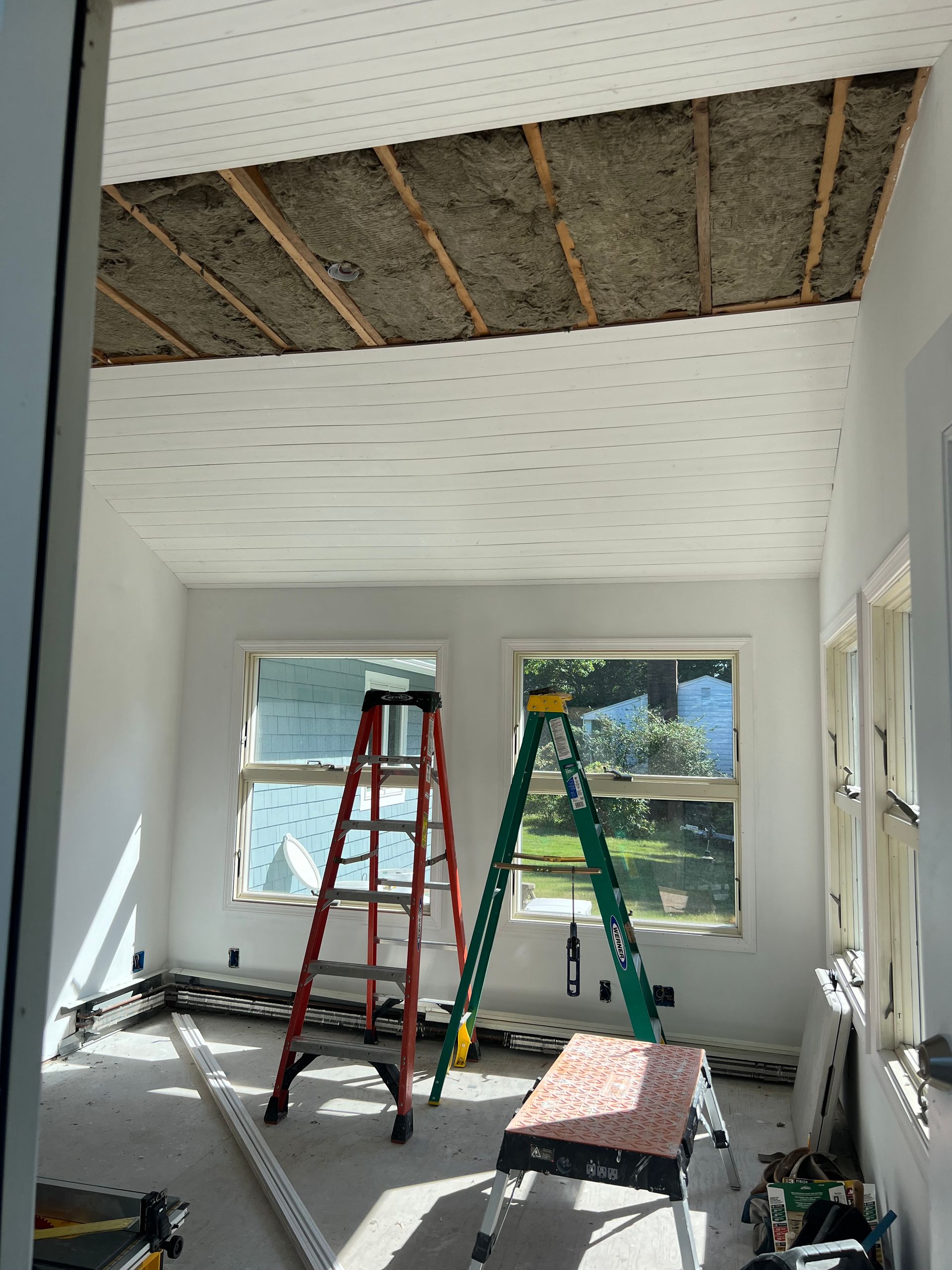 A room with a ladder and a table in it.