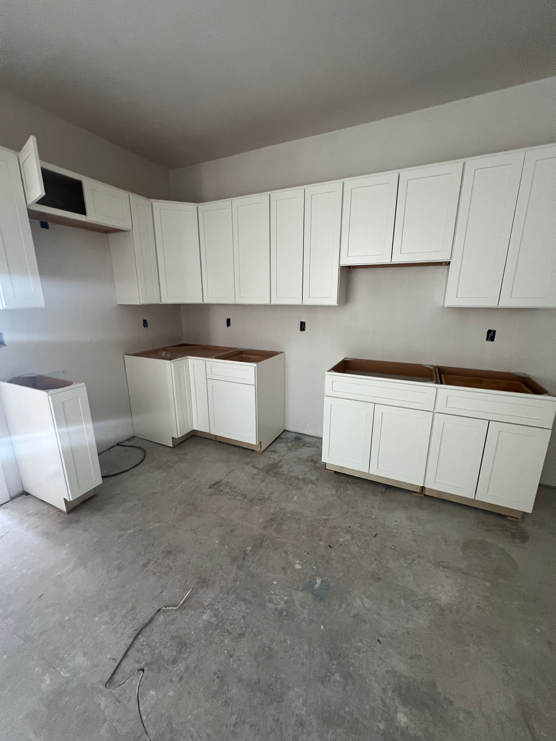 A kitchen with white cabinets and wooden counter tops
