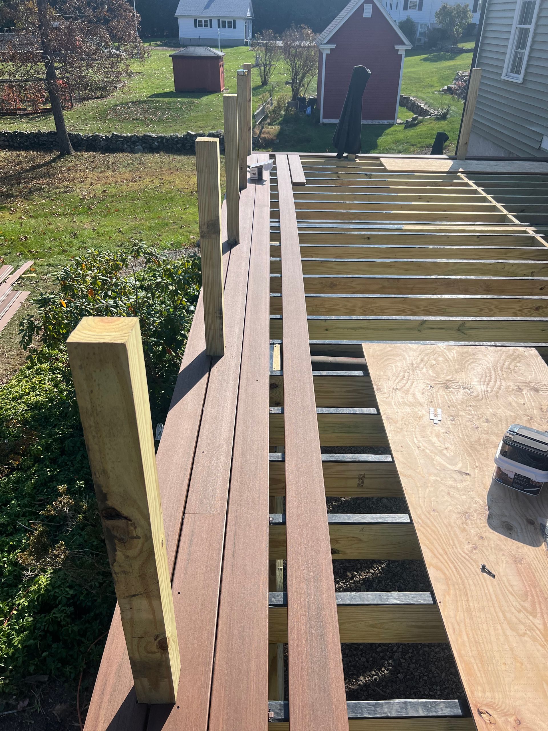 A wooden deck is being built in front of a house