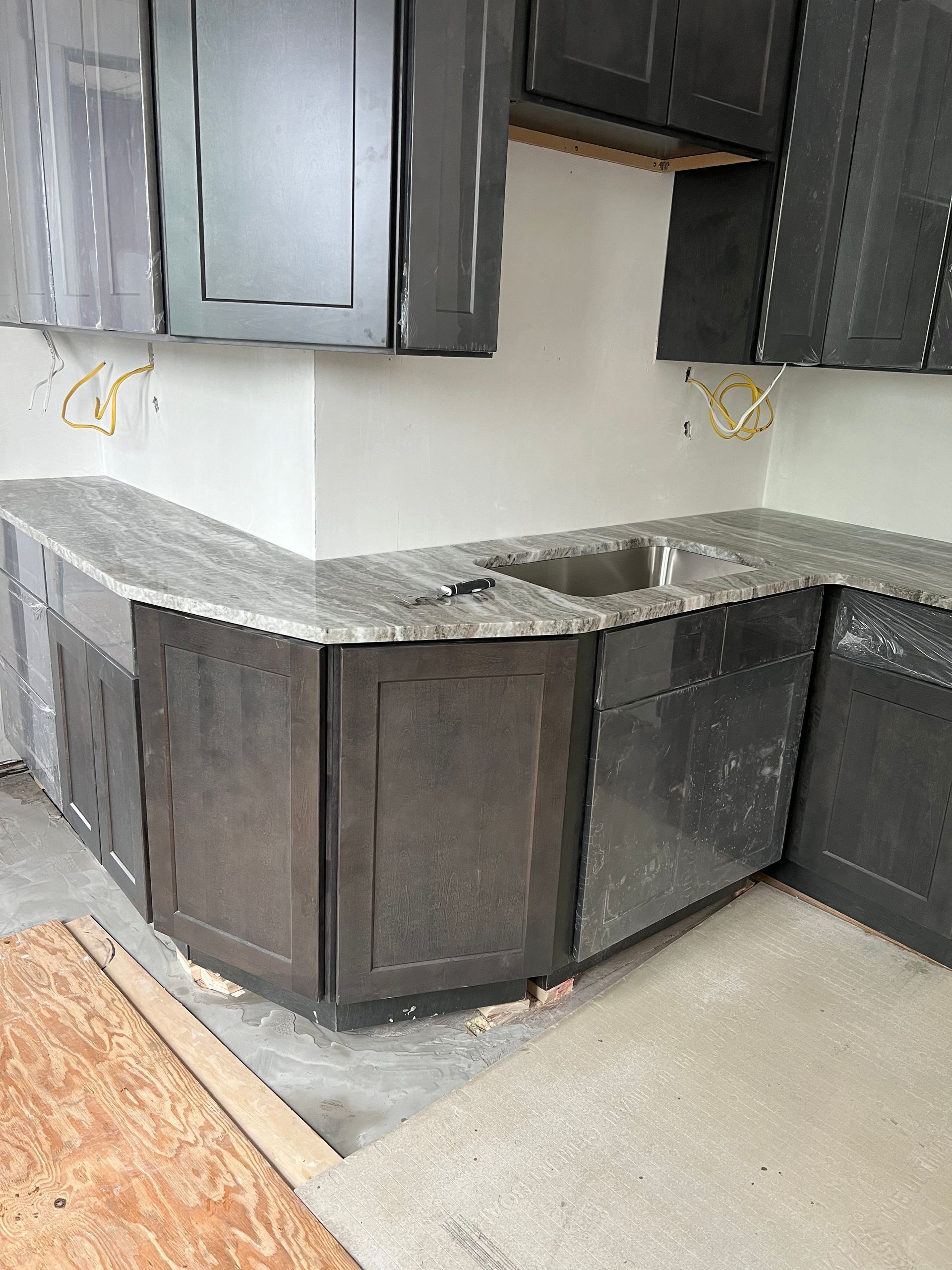 A kitchen with black cabinets and granite counter tops is being remodeled.