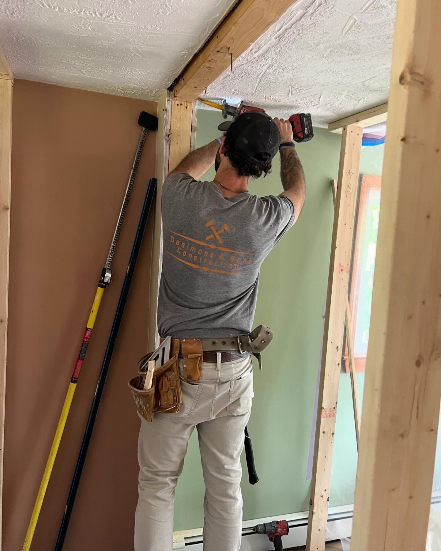 A man is working on a ceiling with a drill.