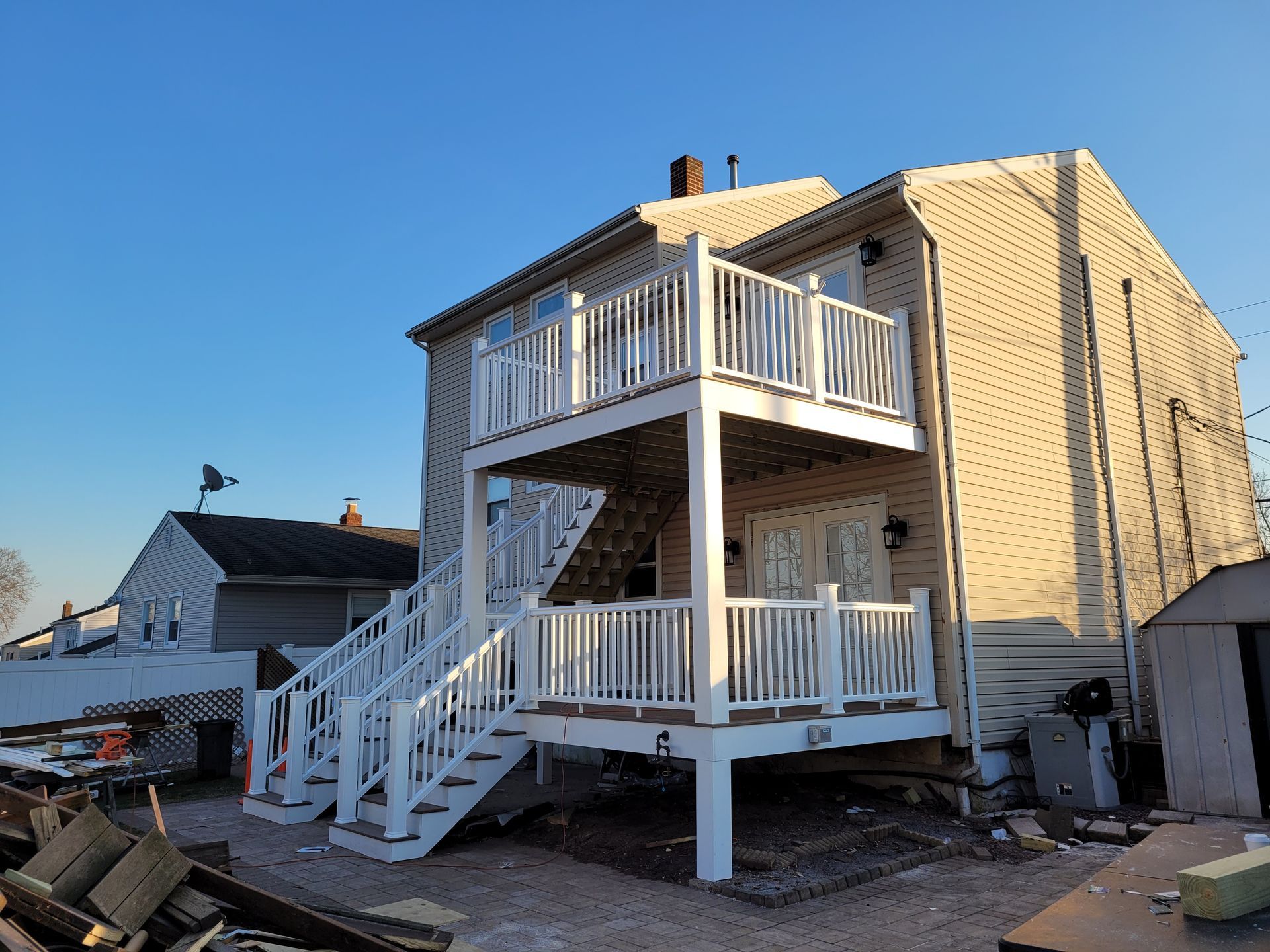 The back of a house with a white deck and stairs