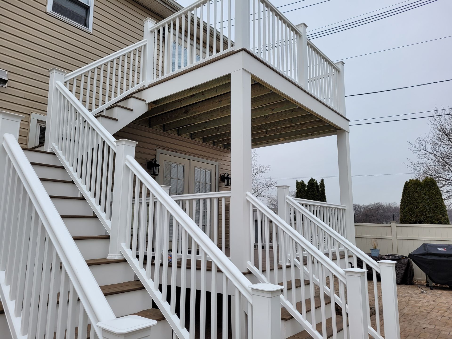 A white deck with stairs leading up to it.