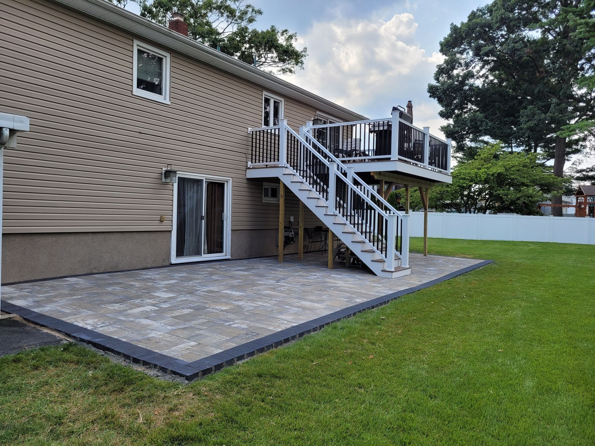 A house with a patio and stairs in the backyard.
