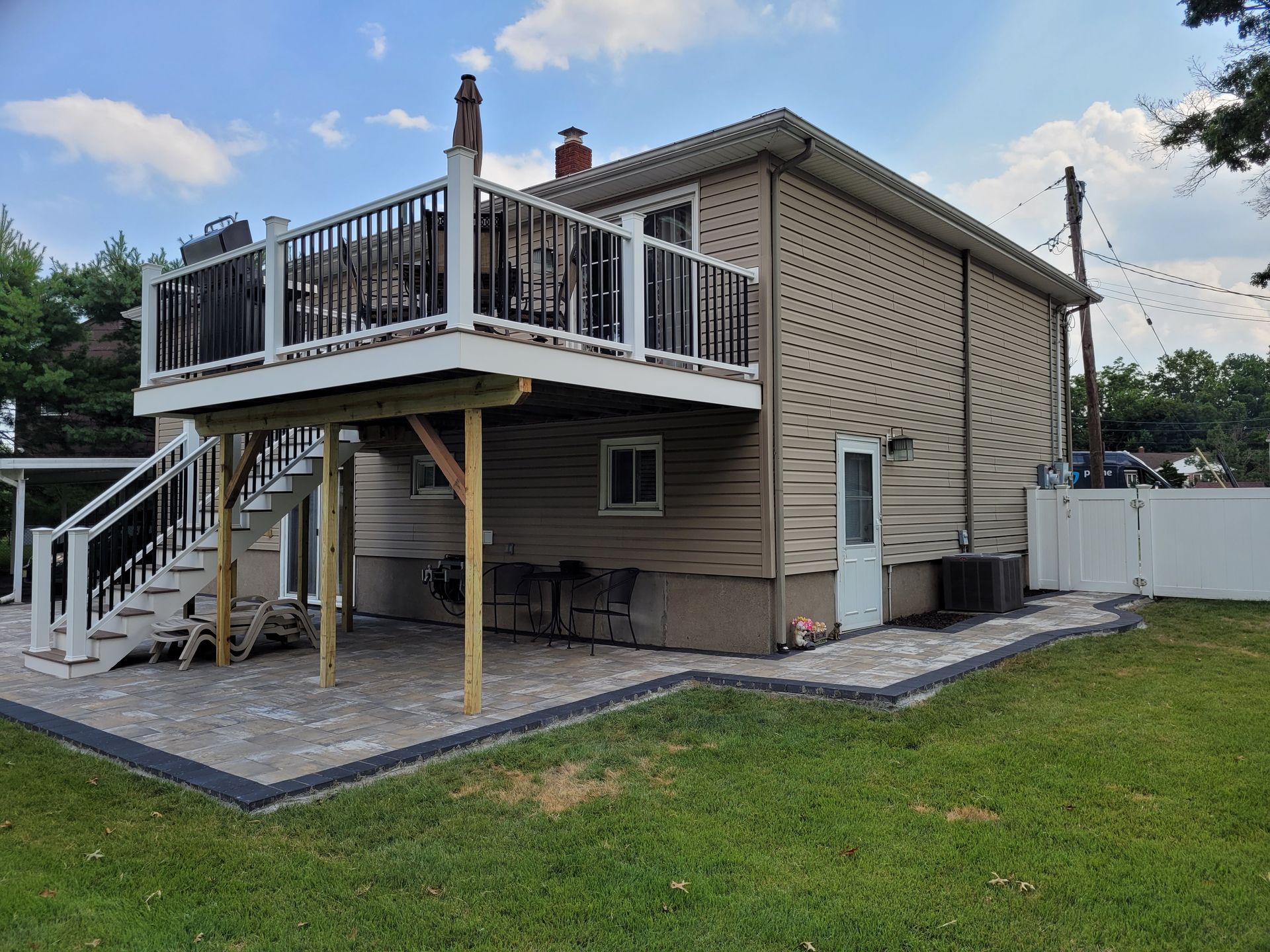 A house with a large deck and stairs in the backyard.