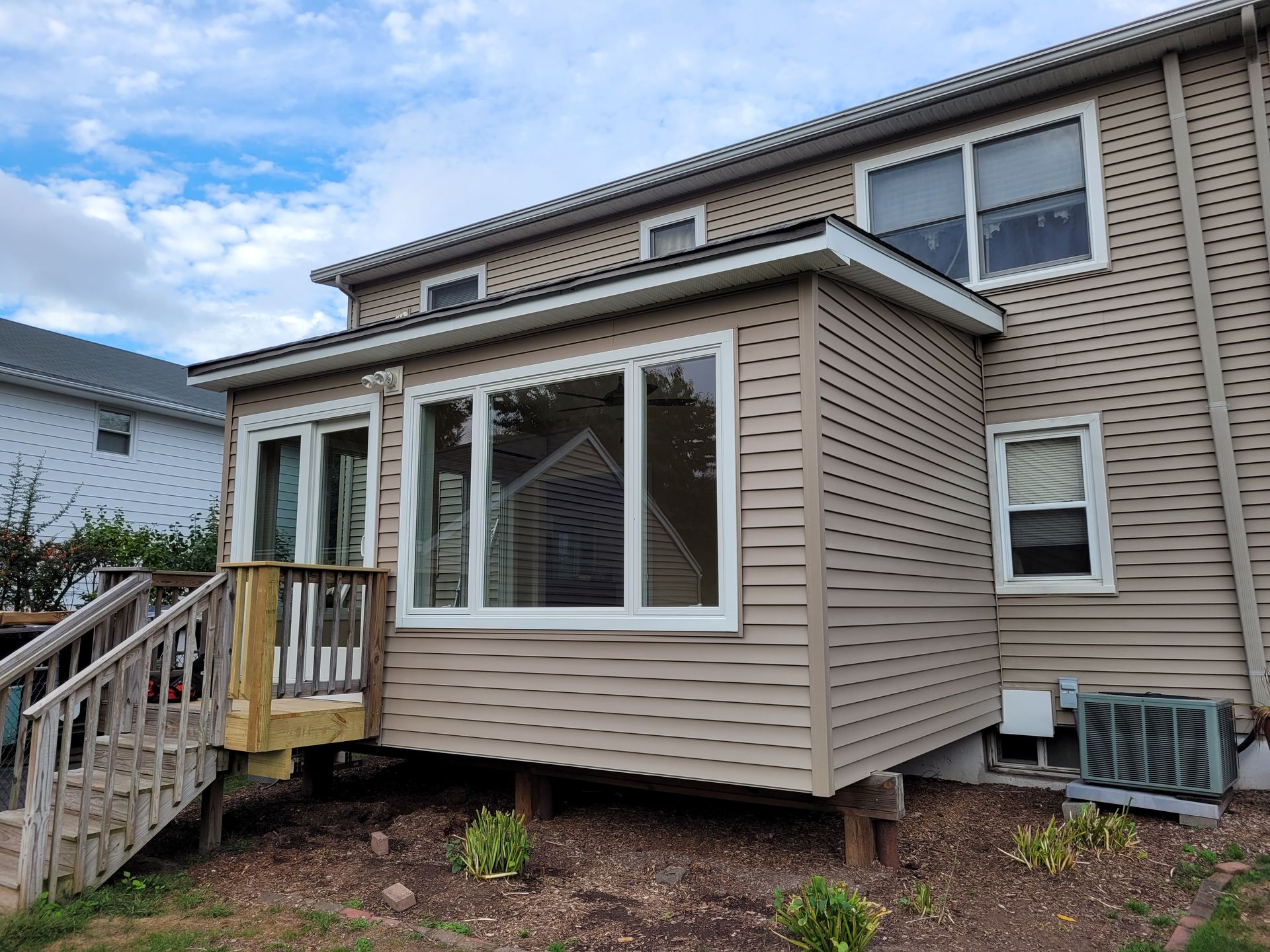 The back of a house with a deck and stairs.