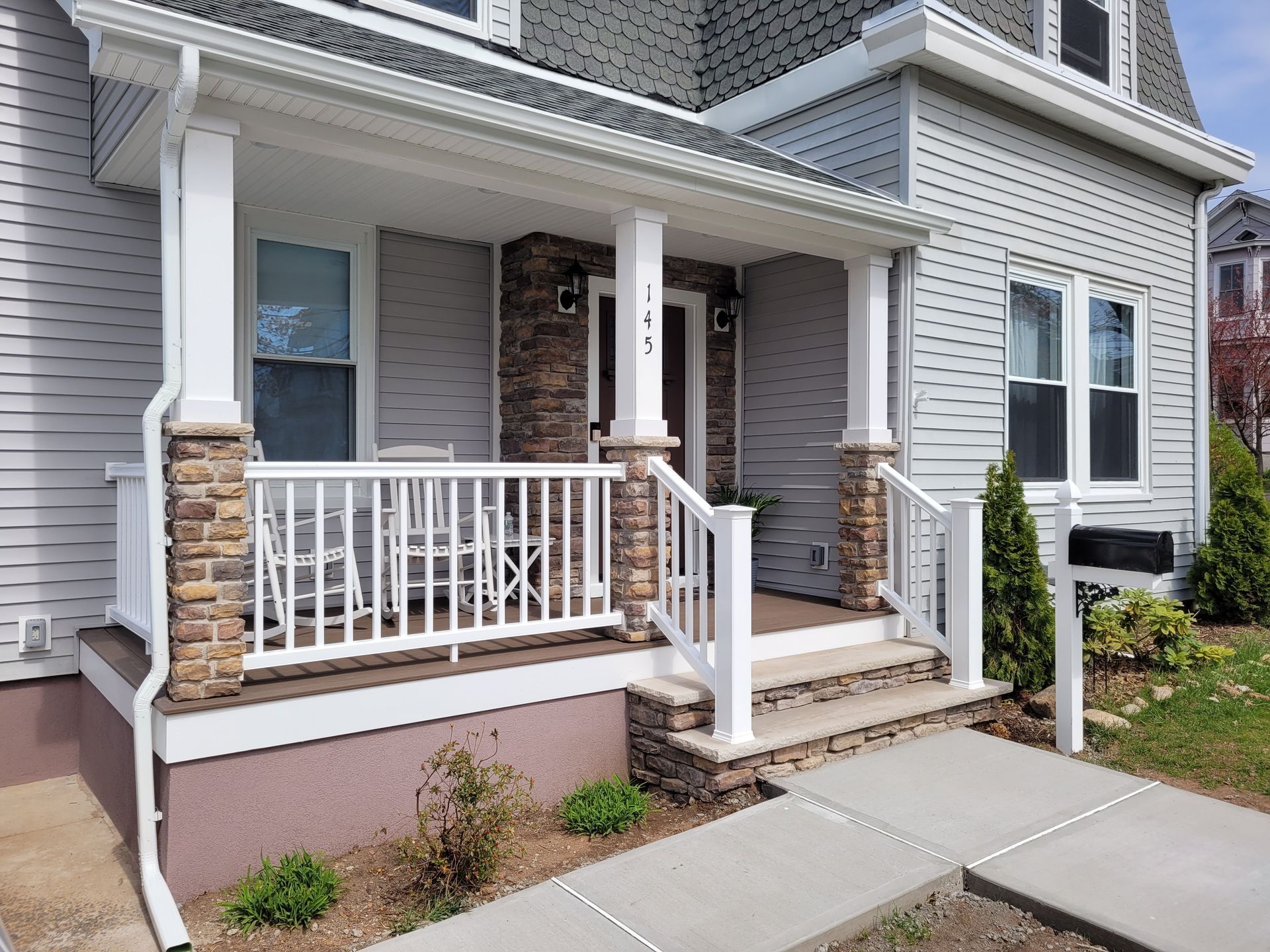 A white house with a porch and stairs