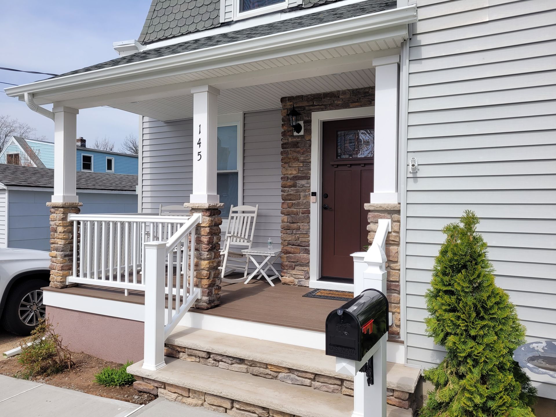 A white house with a porch and a mailbox