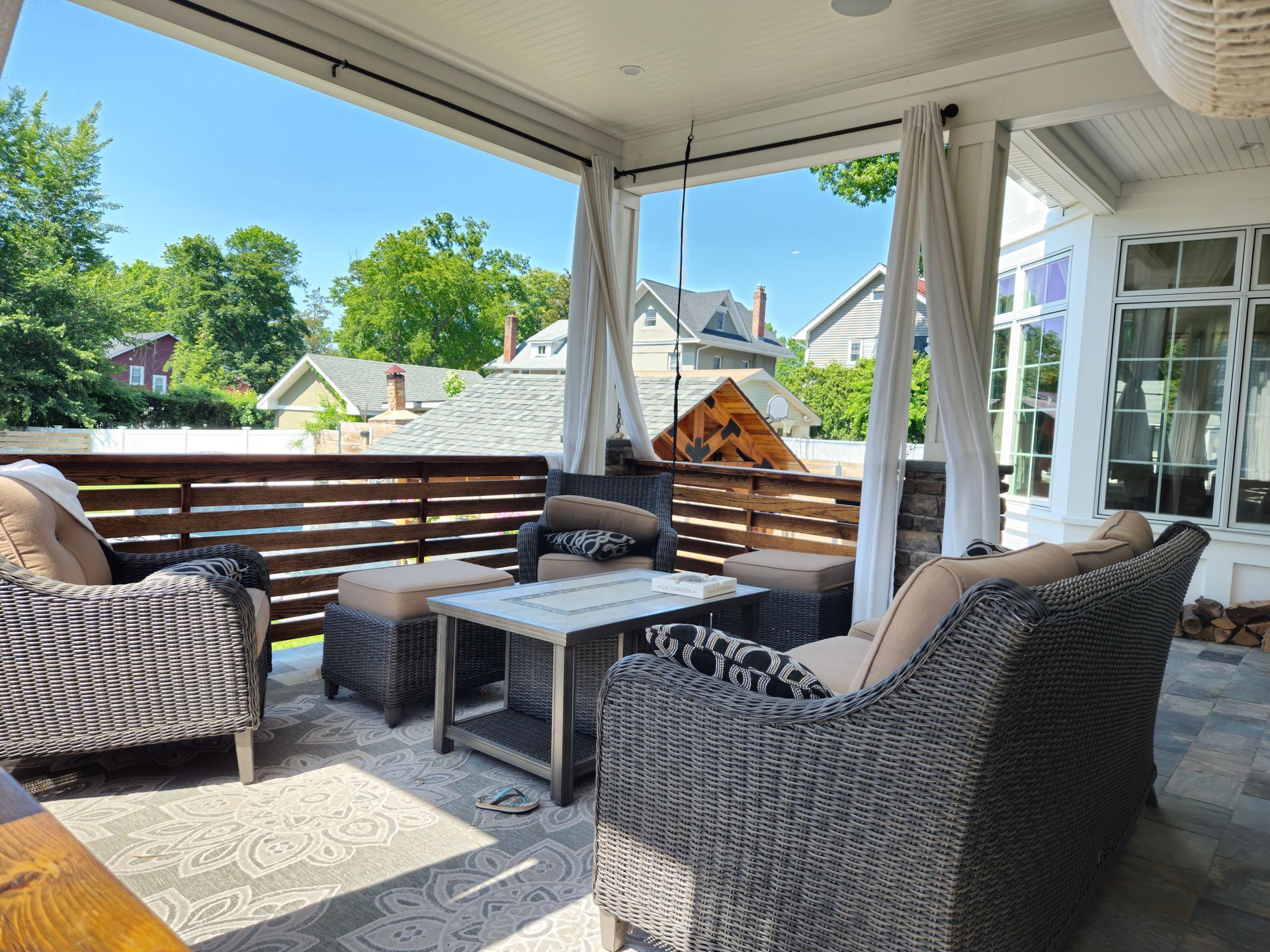 A patio with wicker furniture and a wooden fence