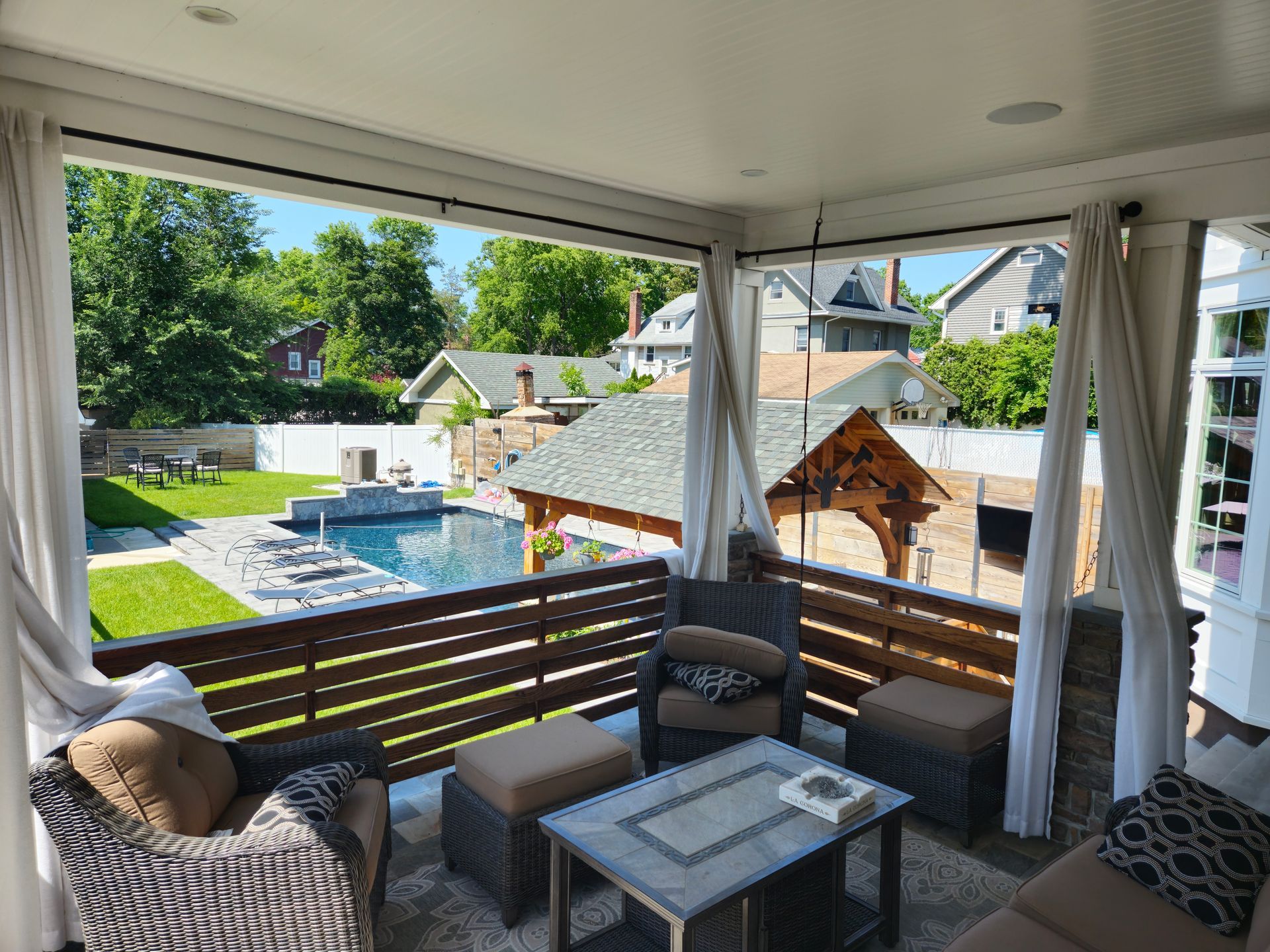 A living room with a couch , chairs and a table with a view of a pool.