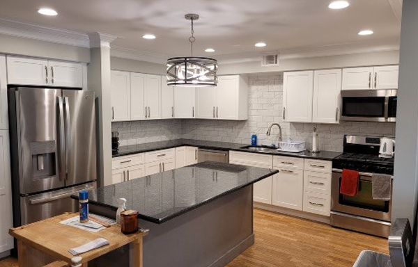 A kitchen with stainless steel appliances and white cabinets.
