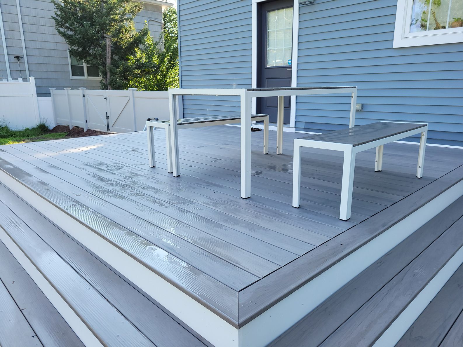 A wooden deck with a table and benches on it