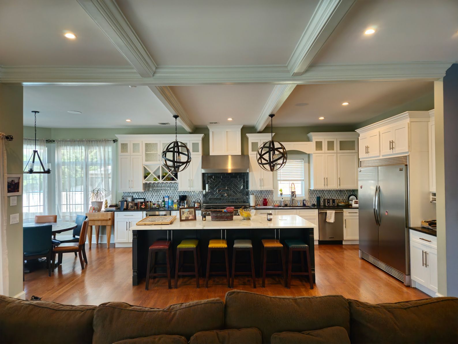 A living room with a couch and a kitchen in the background