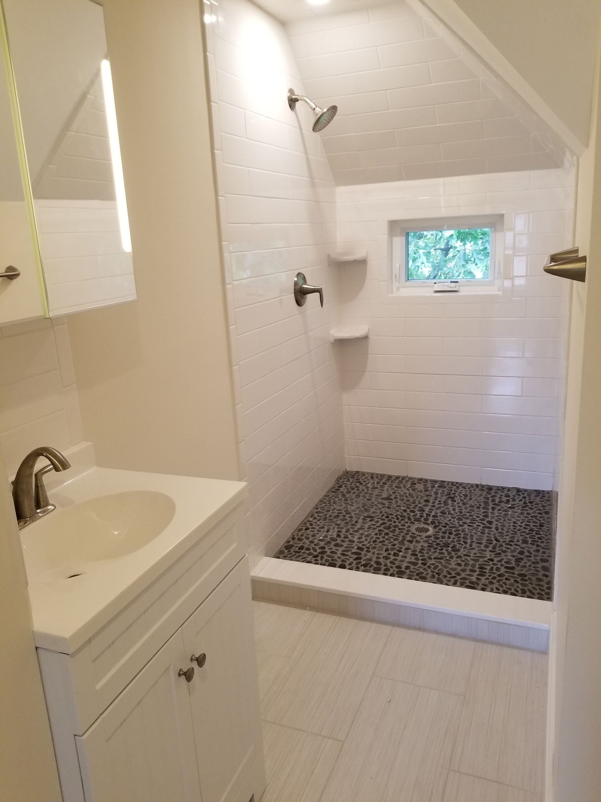 A bathroom with a sink and a walk in shower