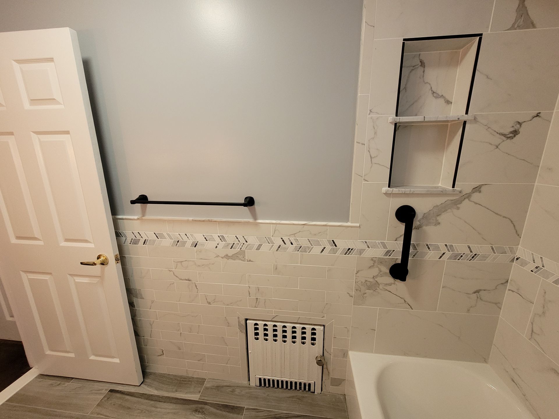 A bathroom with a bathtub and a door