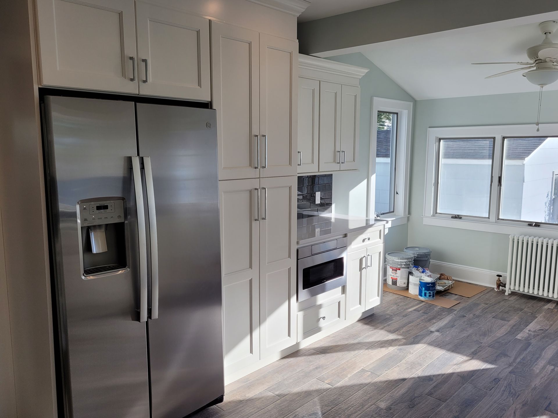 A kitchen with stainless steel appliances and white cabinets.