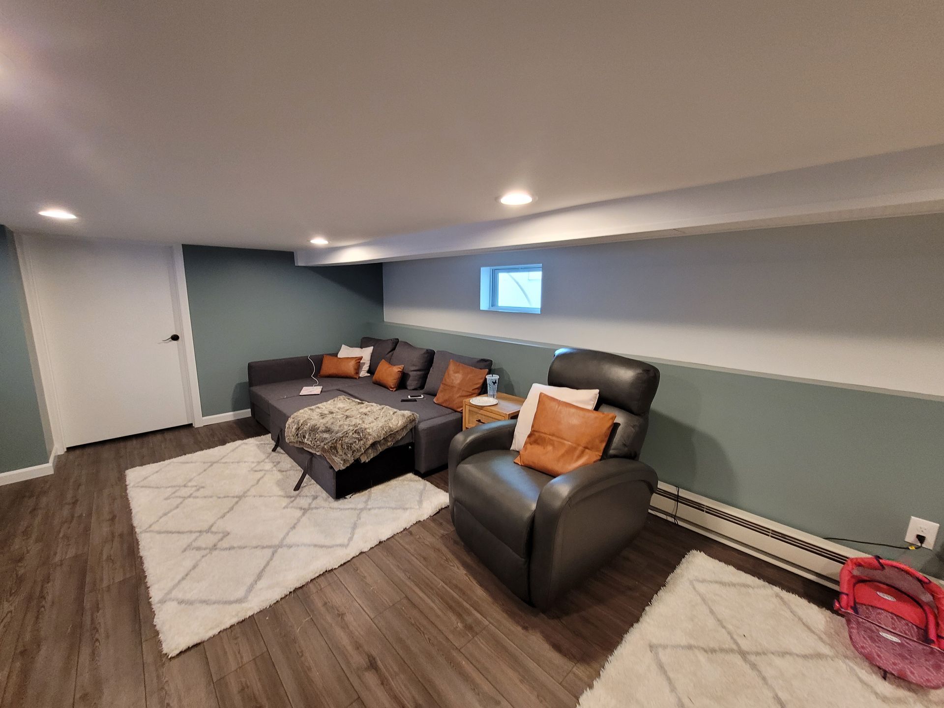 A living room with a couch, chair, and rug.