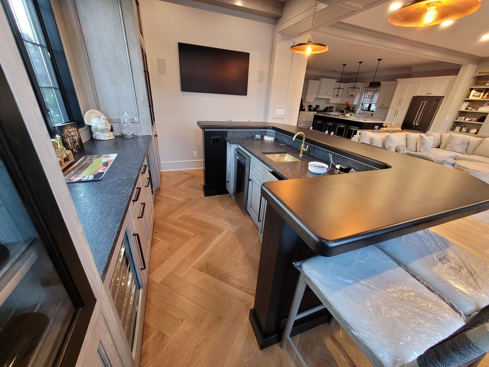 A kitchen with a large island and a flat screen tv on the wall.
