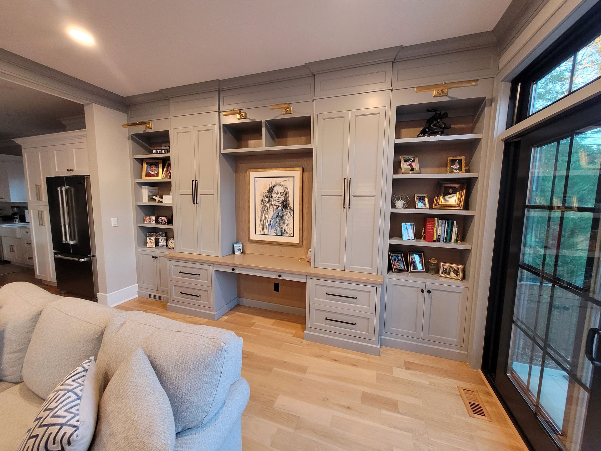 A living room with a couch, desk and shelves.
