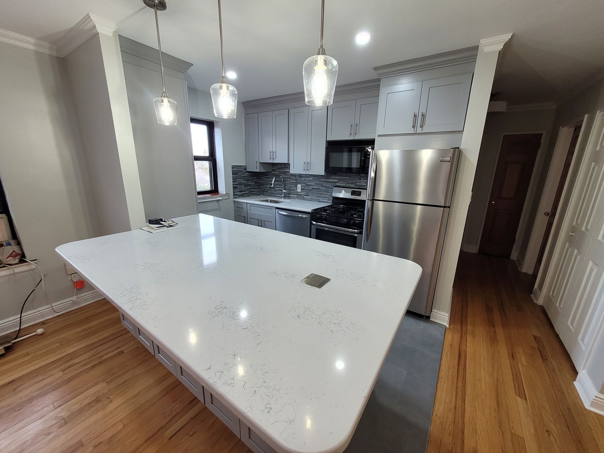 A kitchen with a large island and stainless steel appliances