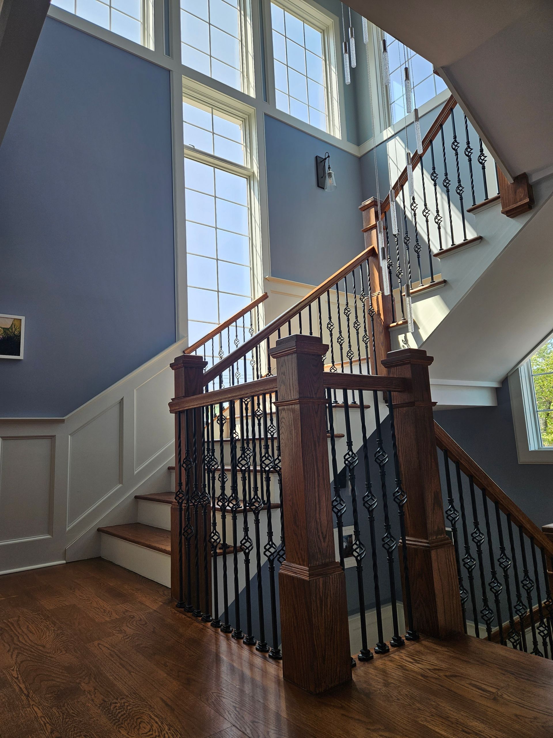 A staircase in a house with lots of windows and a wooden railing.